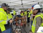A student in a reflective vest and hard hat speaks to a vendor at Pierce County Construction Career Day 2026